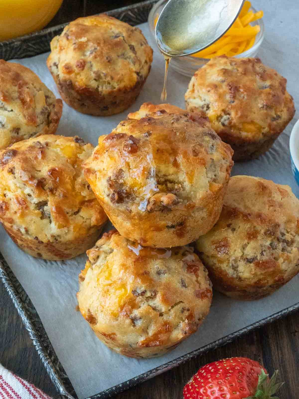 A tray of golden brown sausage muffins with gravy.