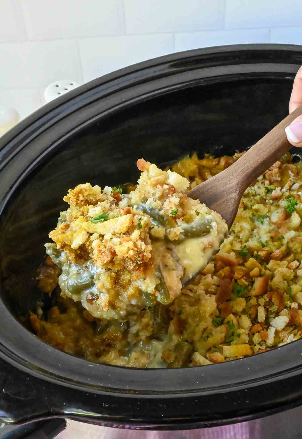 A wooden spoon scooping up some chicken stuffing casserole.