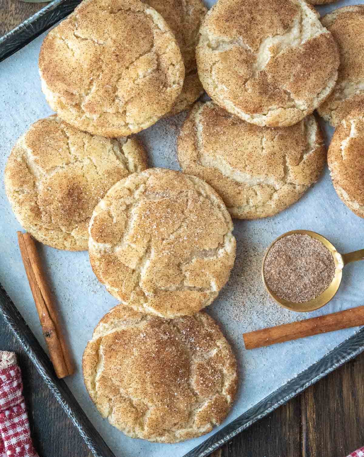 A pile of snickerdoodle cookies on a baking sheet.