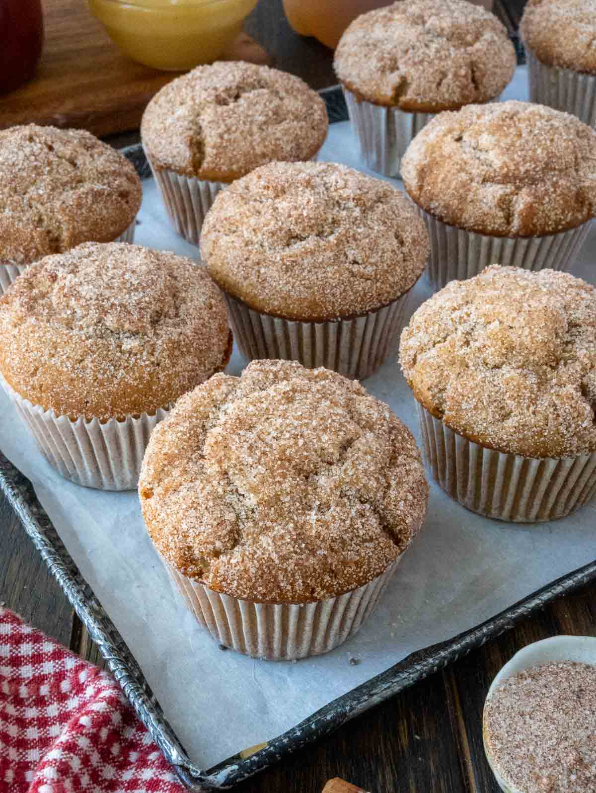 Apple cider muffins on a baking sheet.
