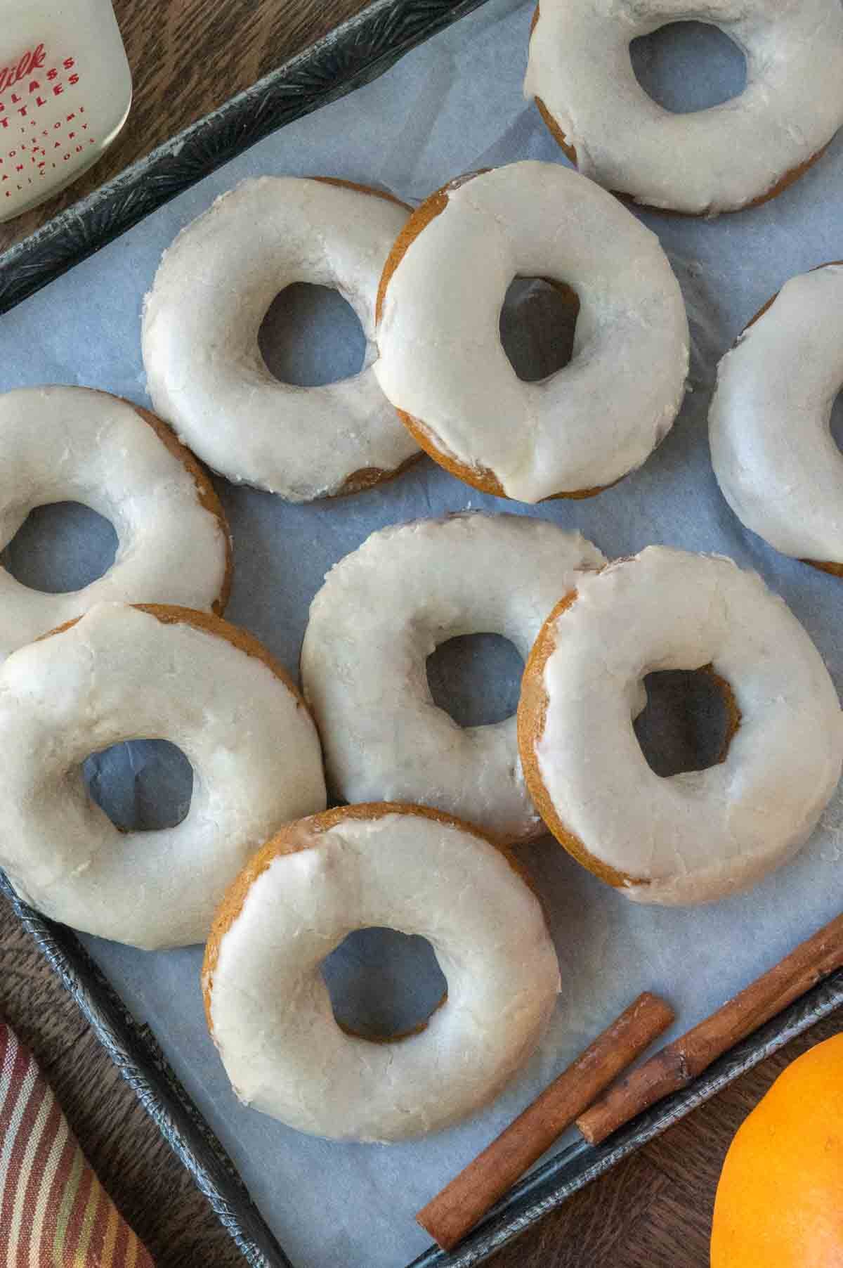 Pumpkin donuts on a baking sheet.