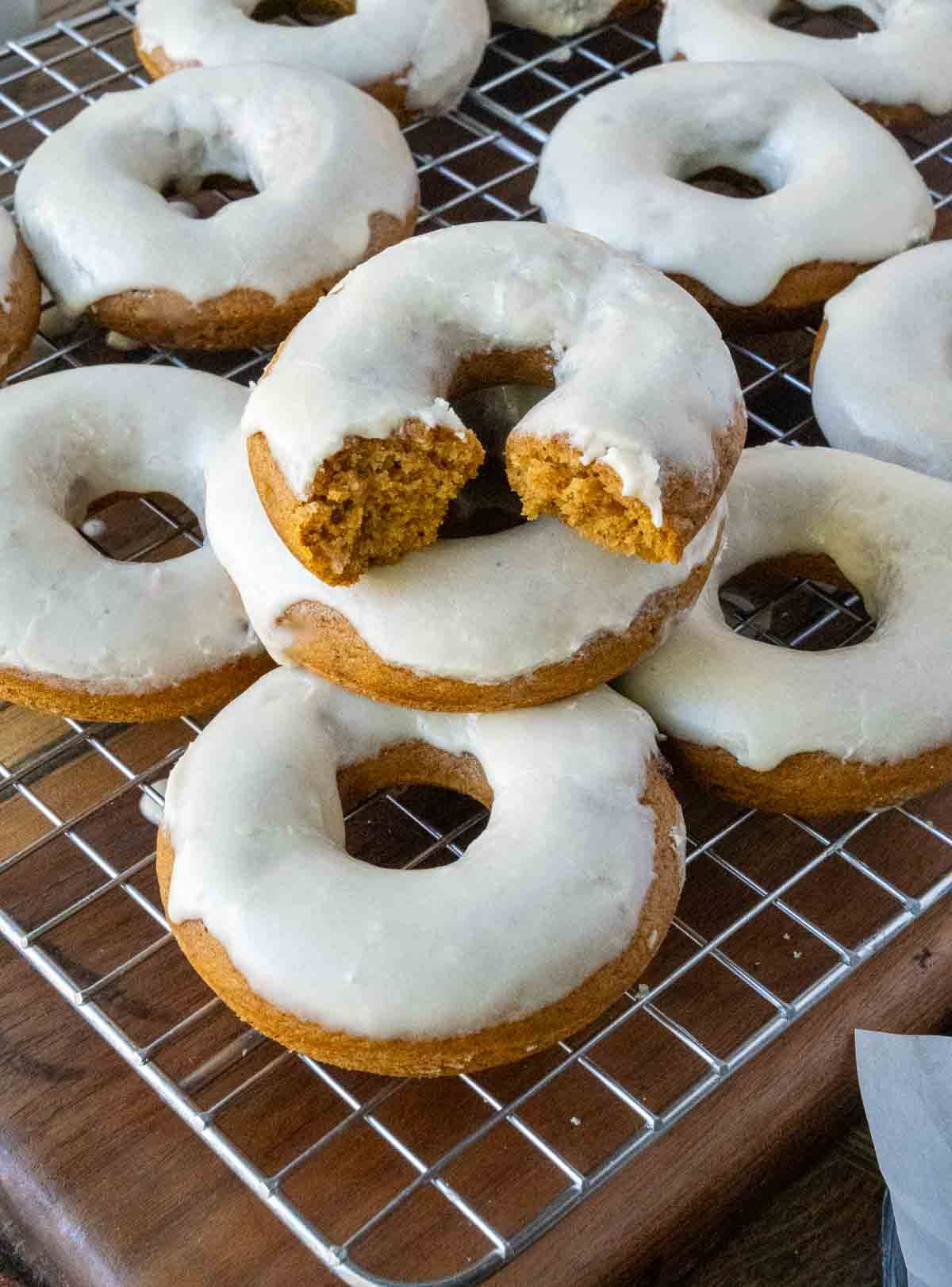 Baked pumpkin donuts on a cooling rack with maple icing.