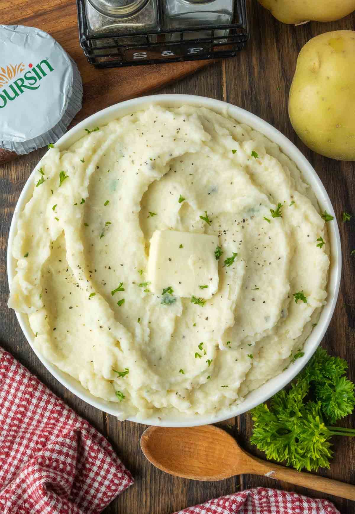 A bowl of Boursin mashed potatoes with a pat of butter.