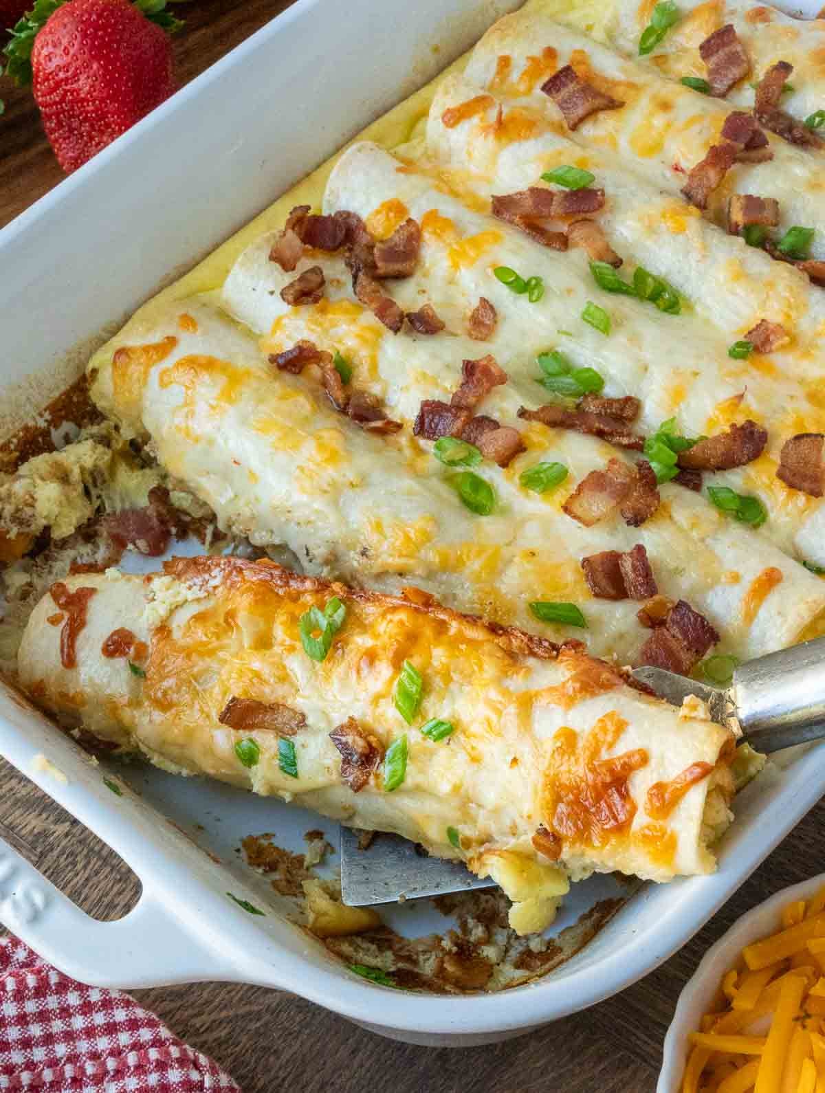 A spatula picking up a breakfast enchilada.