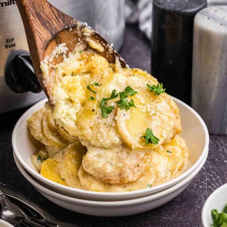 Scalloped potatoes being served into a bowl.