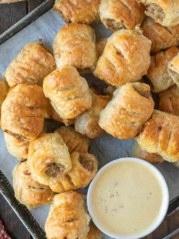 sausage rolls on a platter with honey mustard.