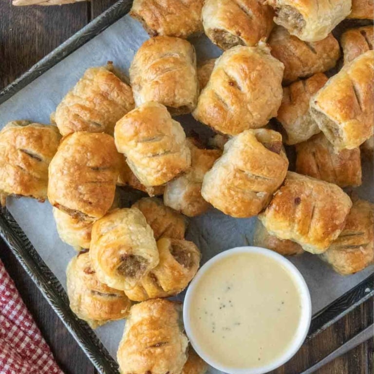sausage rolls on a platter with honey mustard.