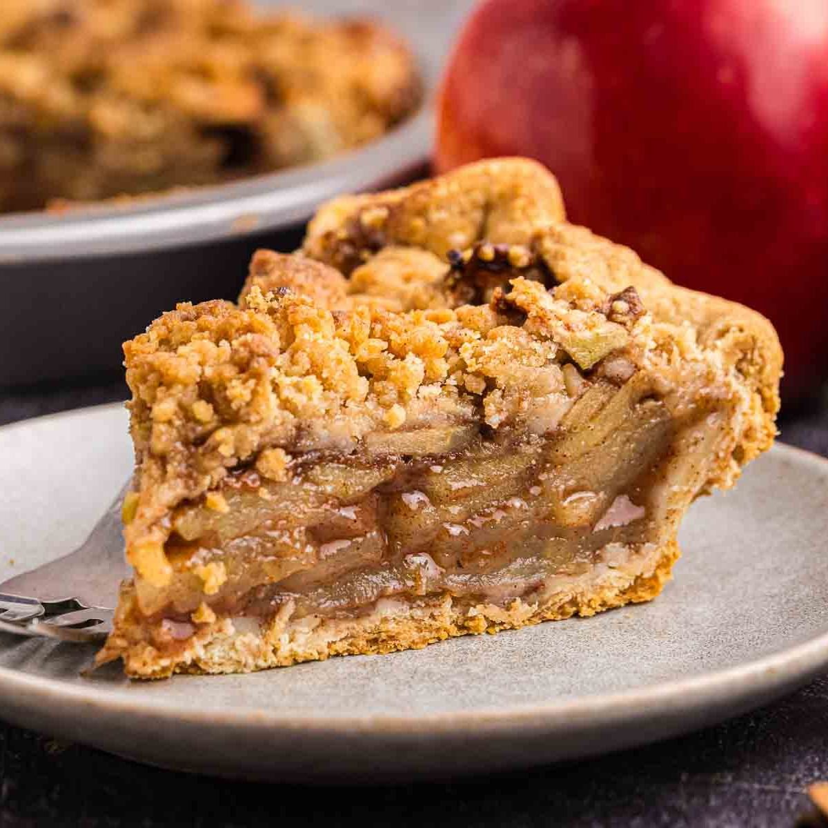 Close up of a piece of apple crumble pie on a plate.