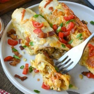 A fork taking a bite out of a breakfast enchilada.