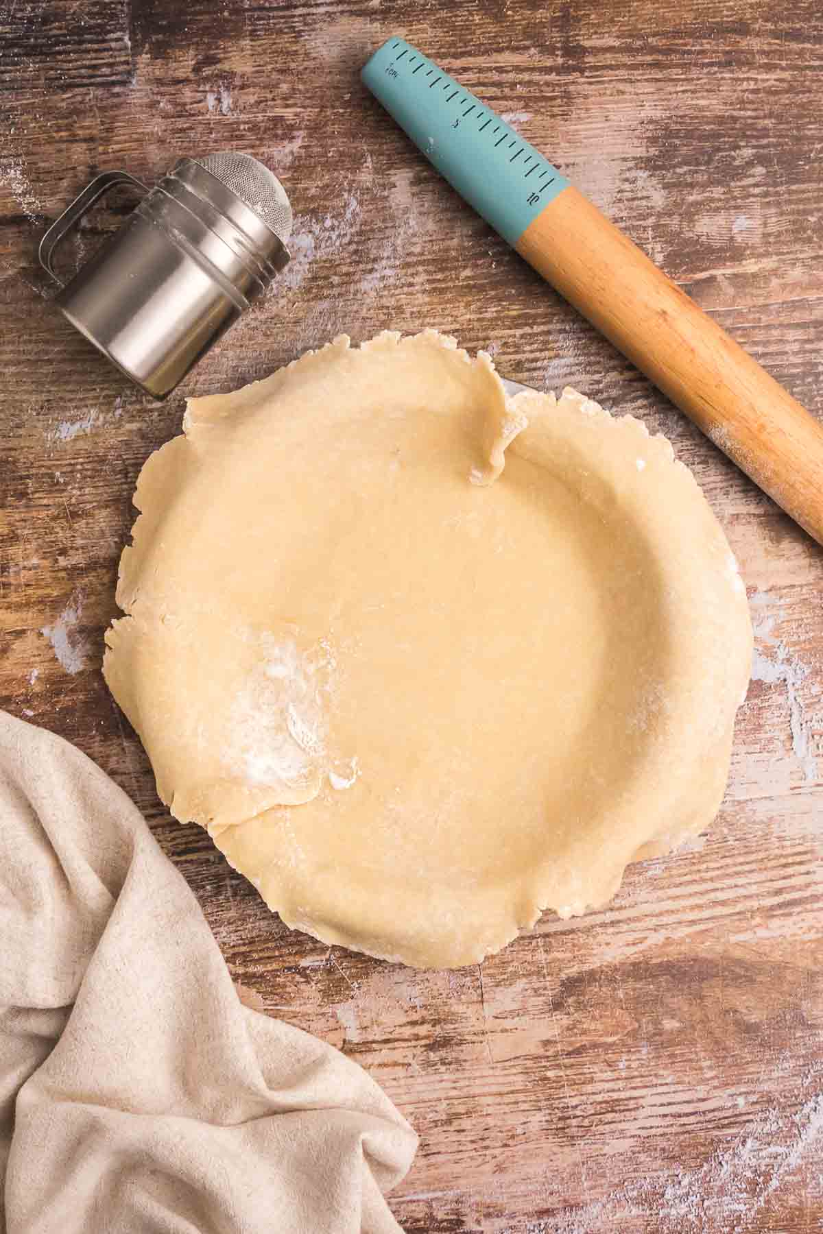 Laying homemade pie crust over a pie pan.