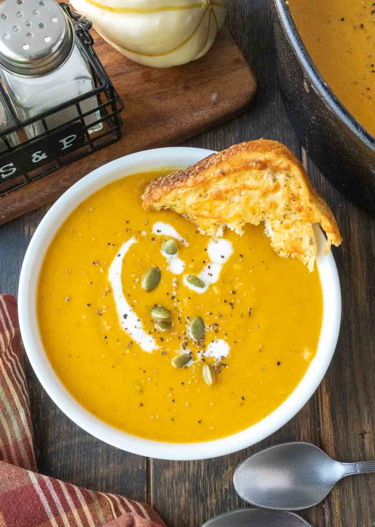 A bowl of copycat panera bread butternut squash soup with a piece of bread.