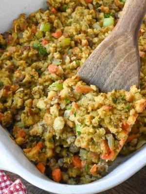 Close up of a wooden spoon taking a scoop of semi homemade box stuffing.