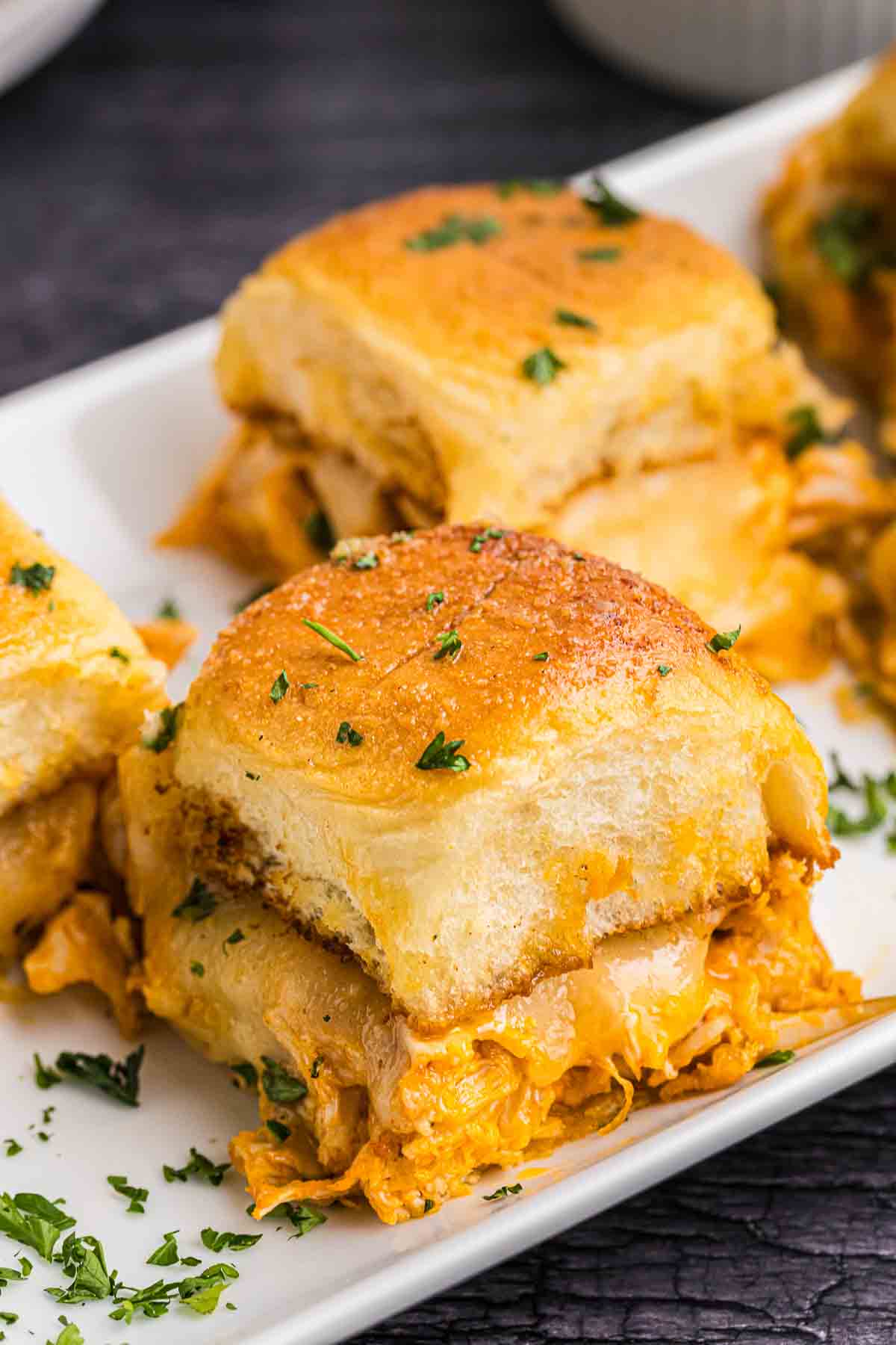A plate with buffalo chicken sliders recipe.