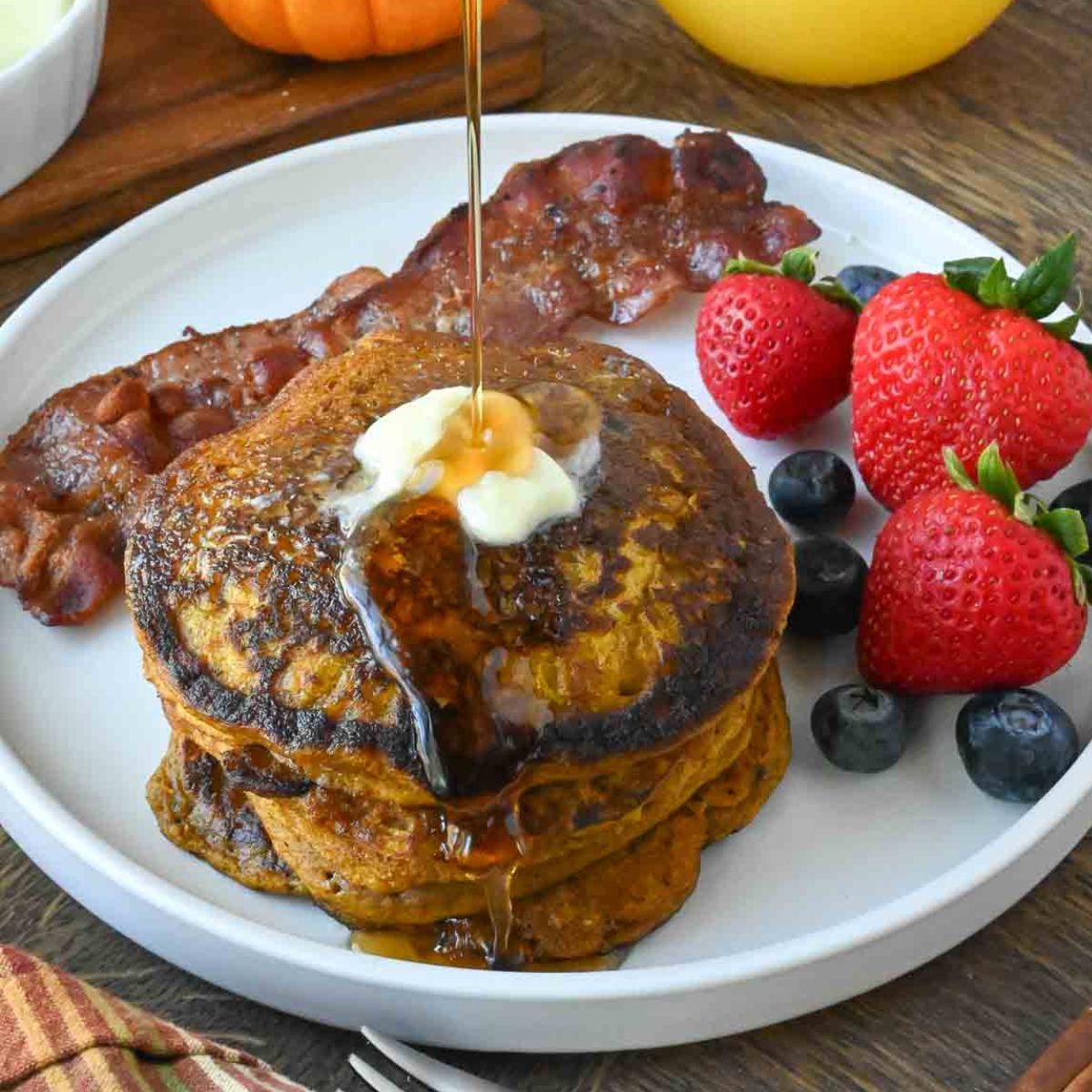 A stack of pumpkin pancakes on a white plate.