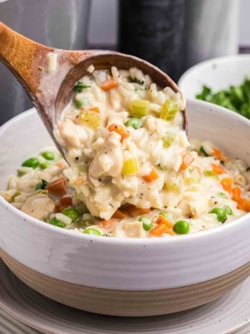 Stirring a bowl of creamy chicken and rice soup.