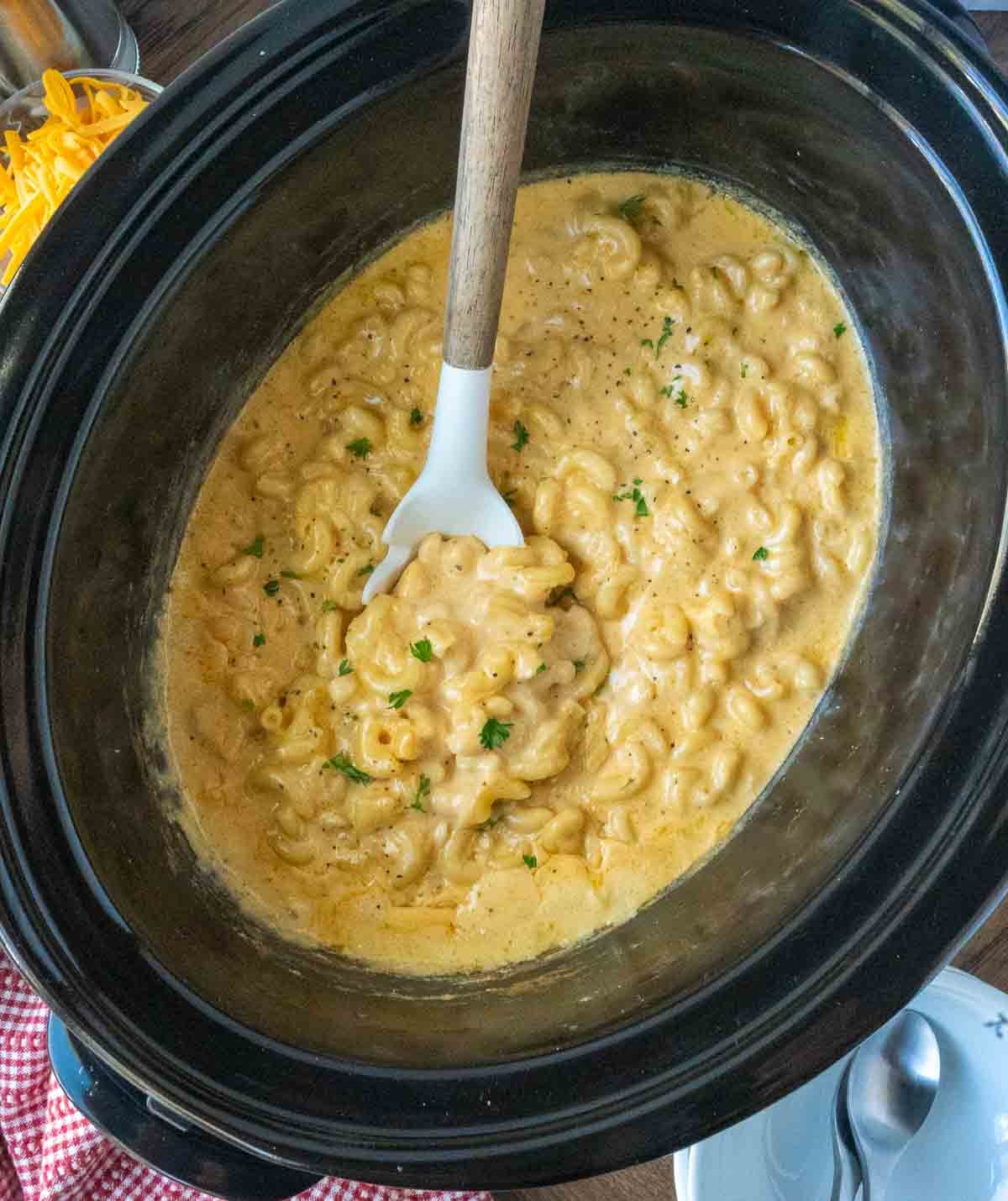 Mac and cheese in a slow cooker with a serving
