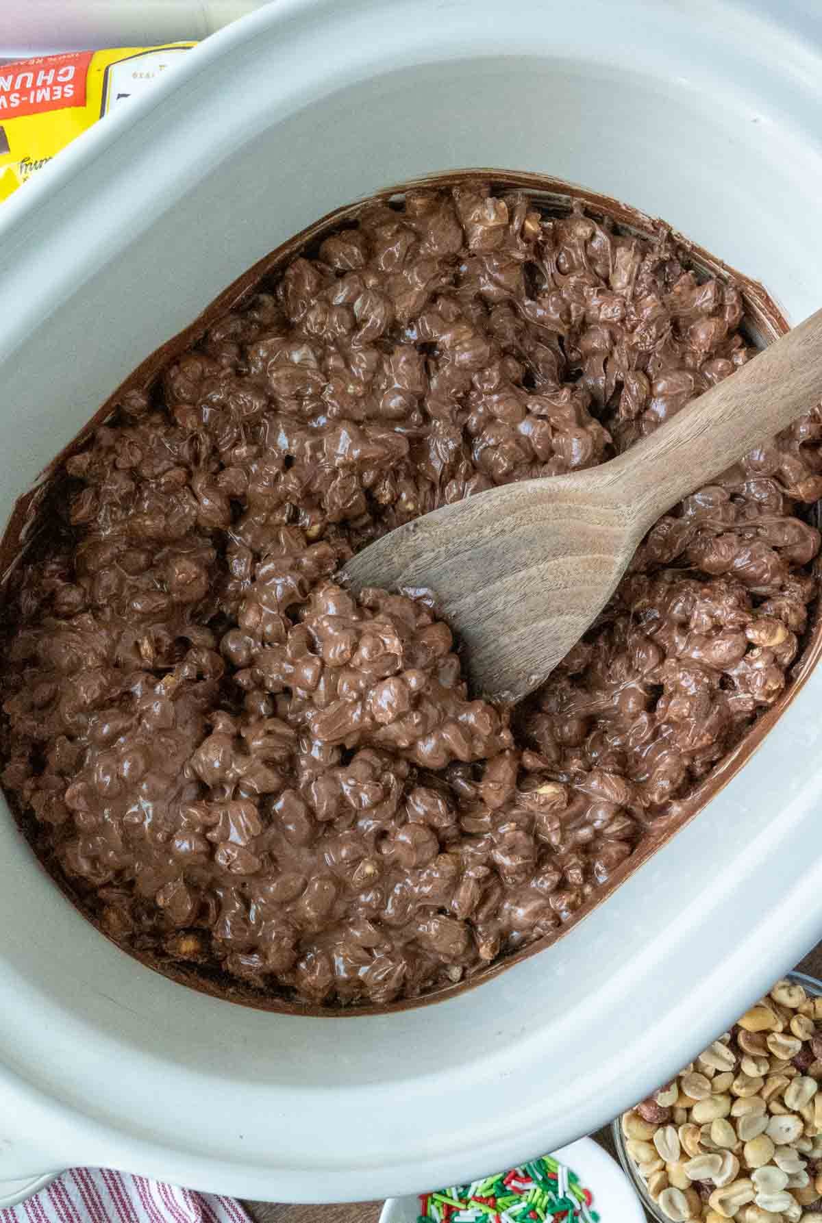 Mixing christmas candy in a slow cooker.