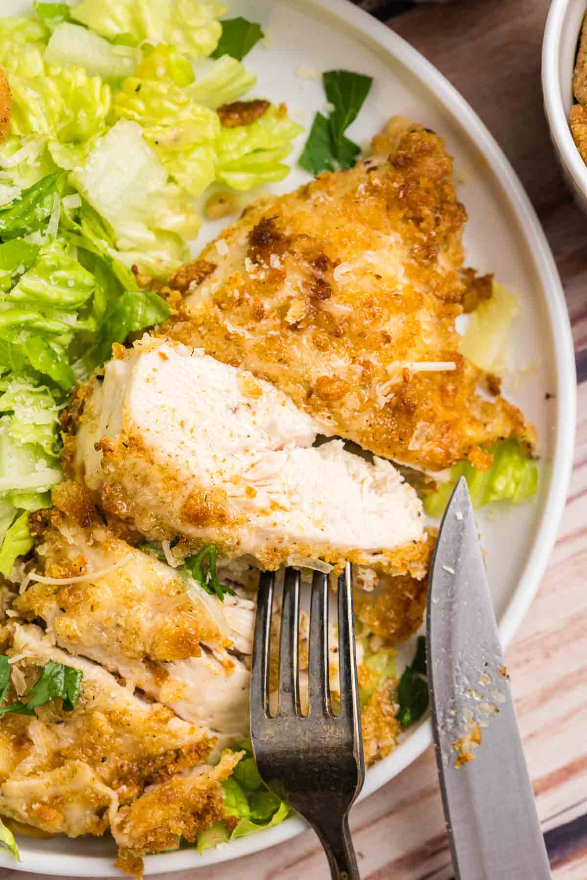 Caesar chicken served with a side of salad.