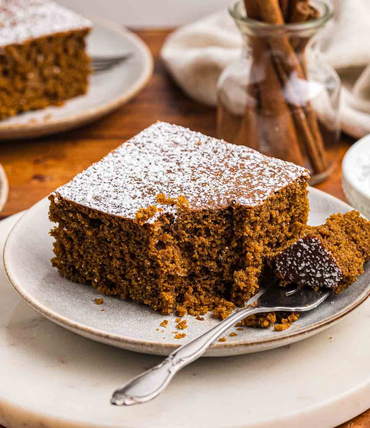 A plate with a fork and a slice of gingerbread cake.