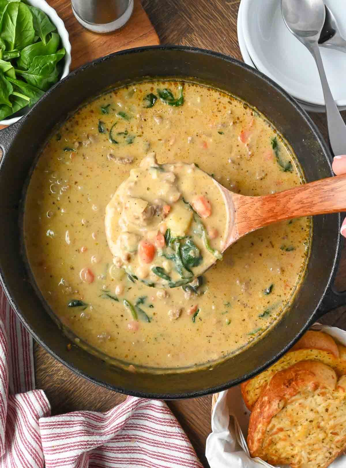 Stirring a pot of Italian sausage white bean soup.
