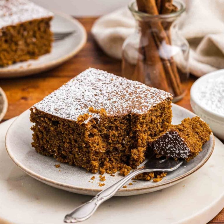 A plate with a fork and slice of gingerbread cake.