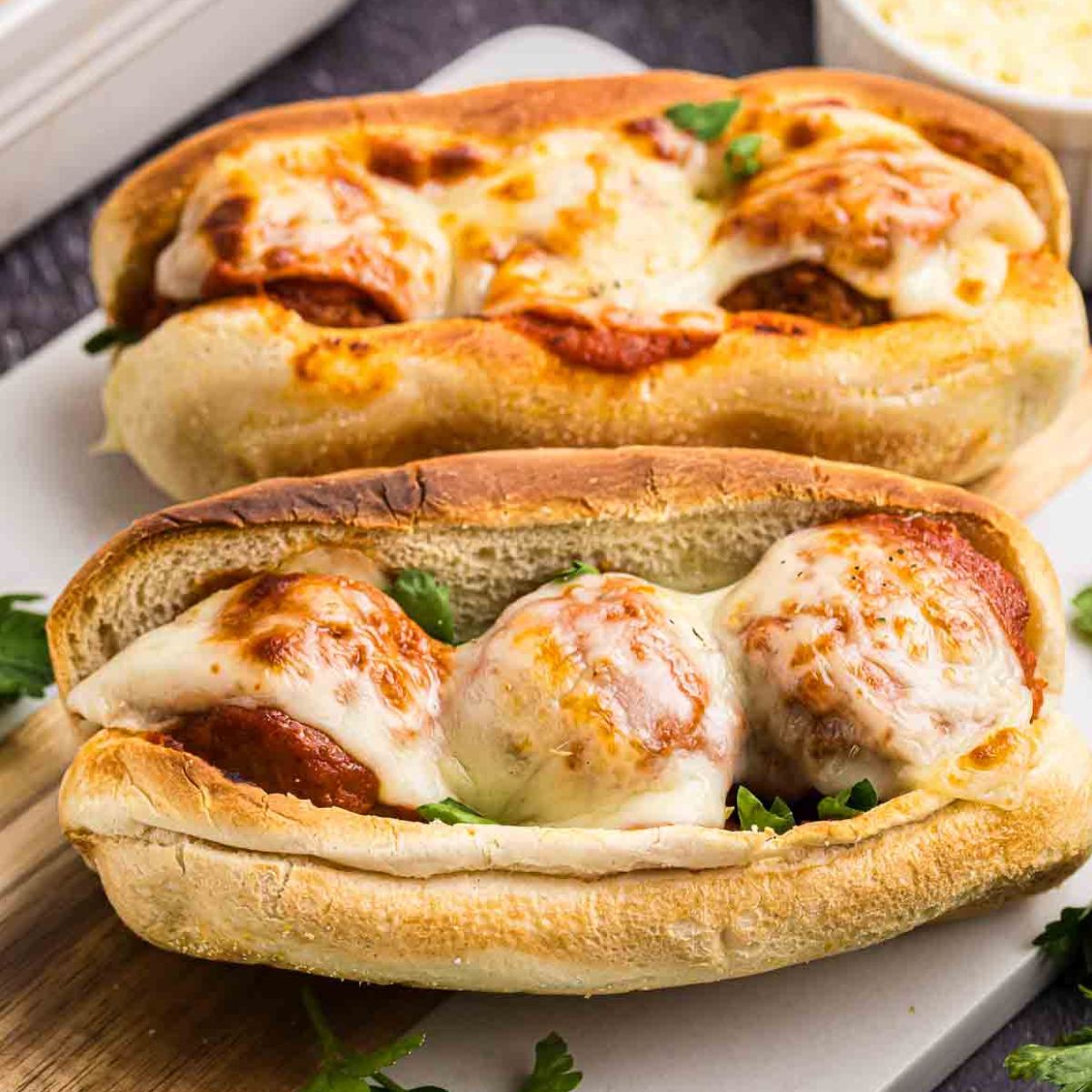 Two slow cooker meatball subs on a serving platter.