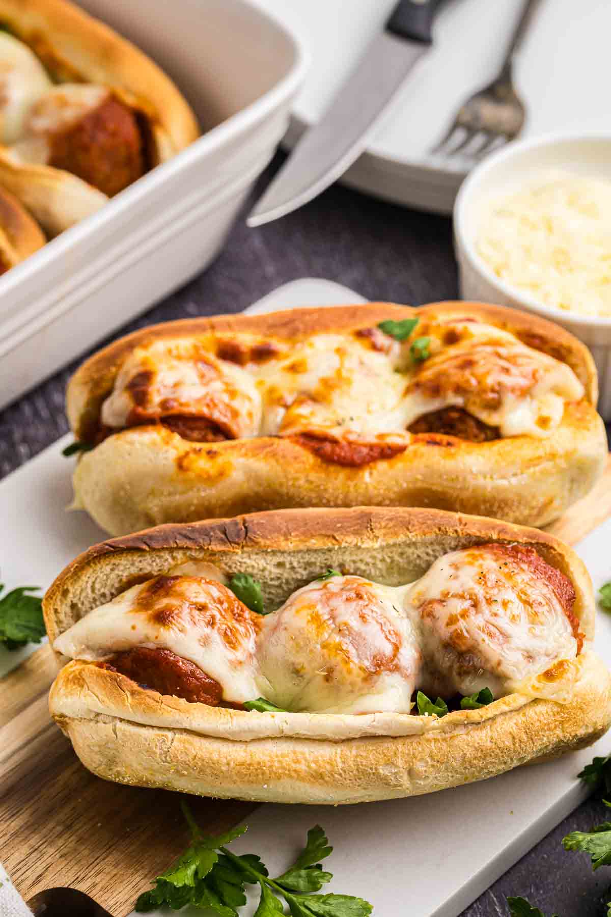 A serving platter with two slow cooker meatball subs.