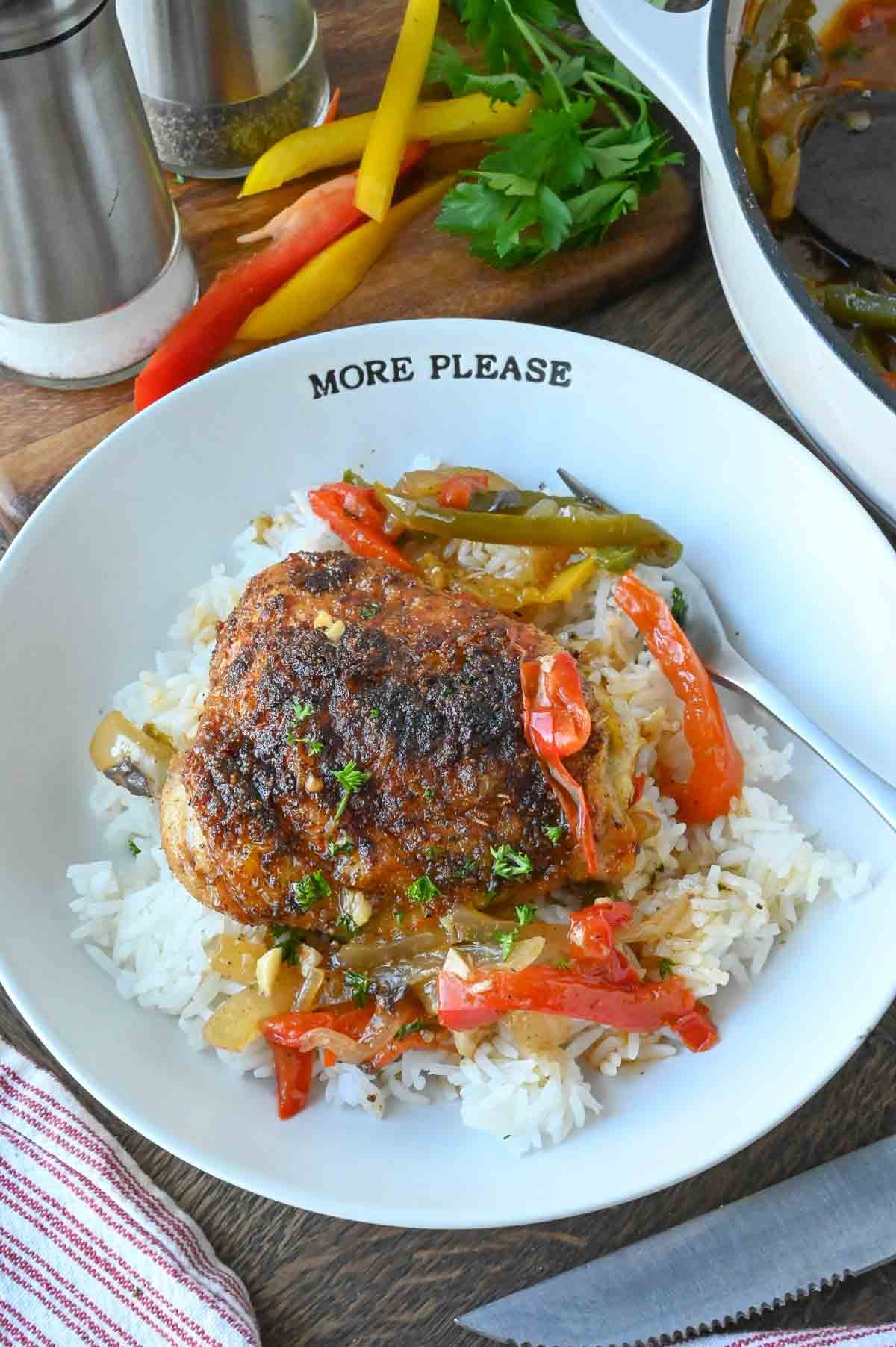 A plate of baked cajun chicken served over rice.