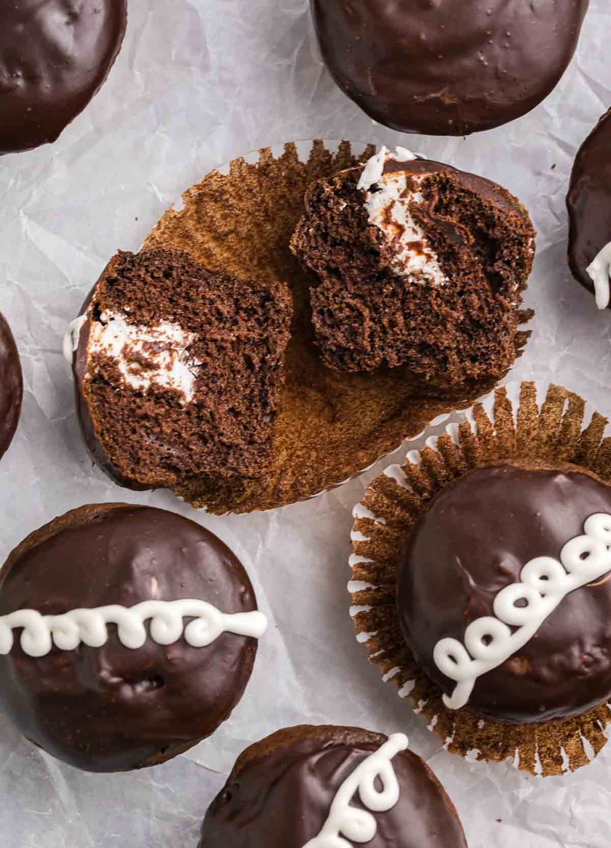 Several copycat hostess cupcakes, one split in half to reveal the frosting inside.