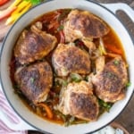 A baking pan with baked cajun chicken thighs.
