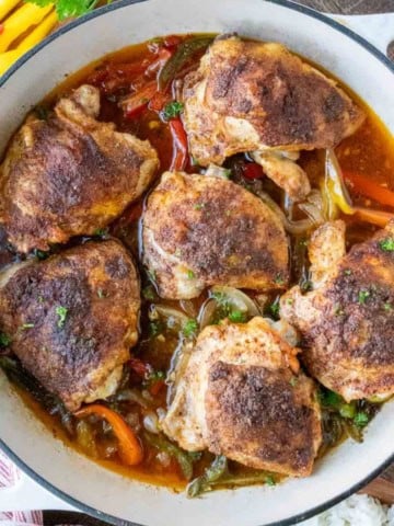 A baking pan with baked cajun chicken thighs.