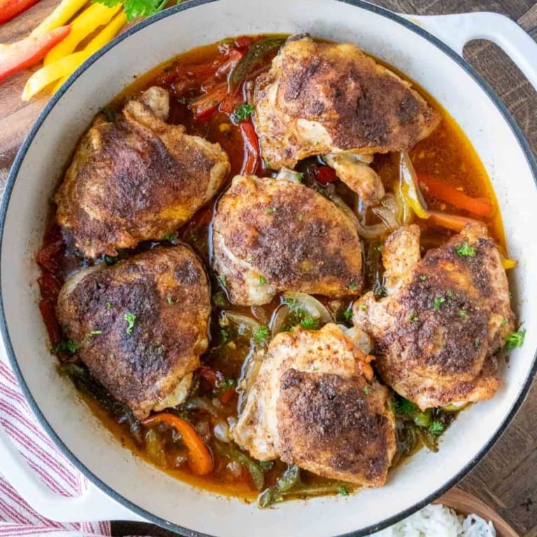 A baking pan with baked cajun chicken thighs.