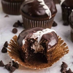 A hostess chocolate cupcake with a bite taken out of it.