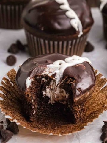 A hostess chocolate cupcake with a bite taken out of it.