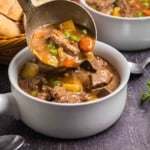 Ladling beef and guinness stew into a bowl.
