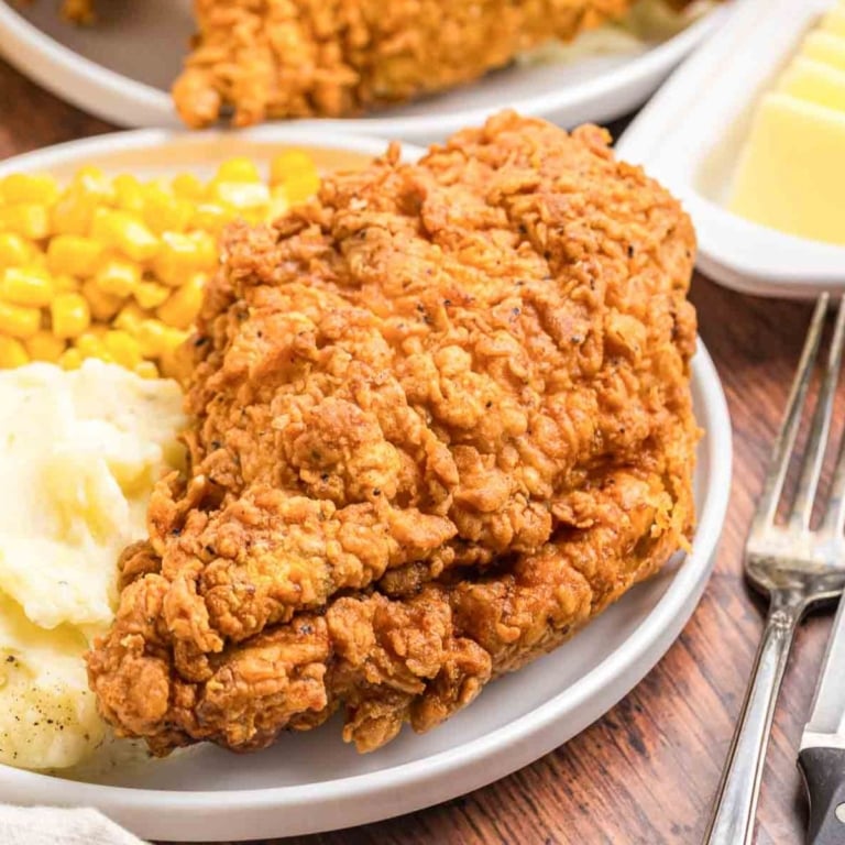 A plate of cracker barrel fried chicken with mashed potatoes and corn.