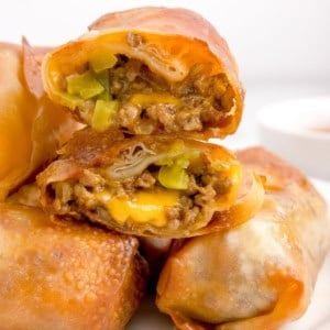 Cheeseburger egg rolls cut in half and stacked on top of each other.