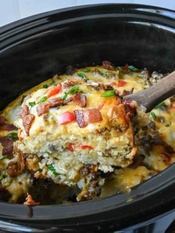 Taking a scoop of slow cooker breakfast casserole.