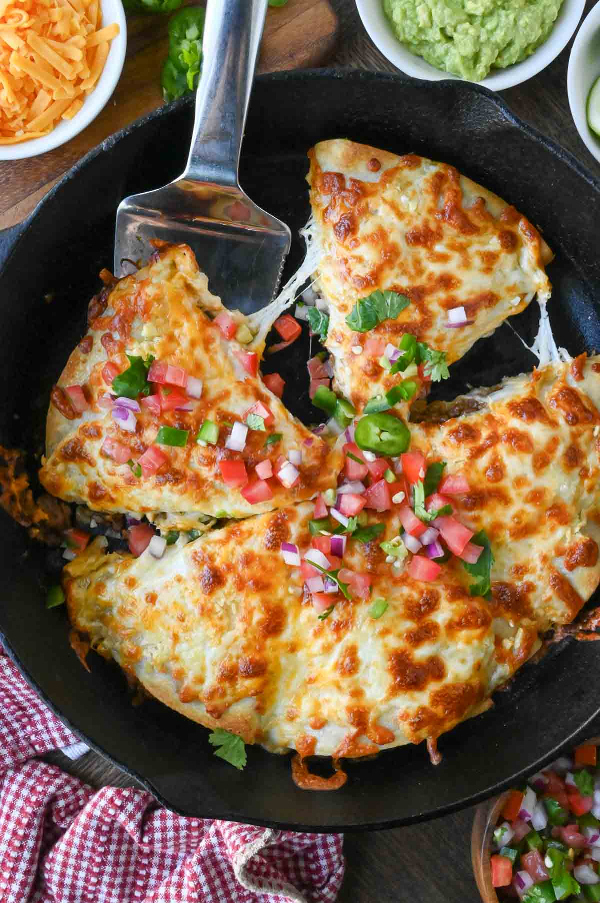 A skillet filled with cheesy beef pockets.