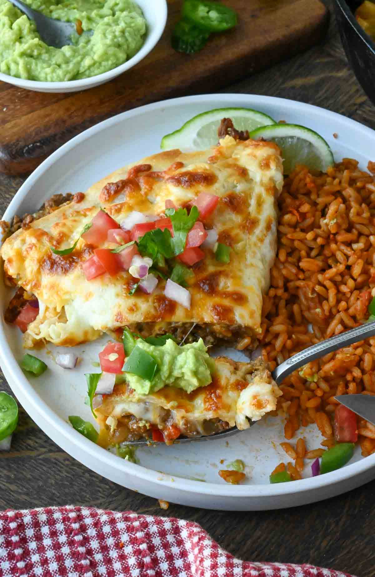 A plate with a cheesy beef pocket served with seasoned rice.