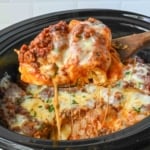 Taking a big scoop of crockpot lasagna from the slow cooker.