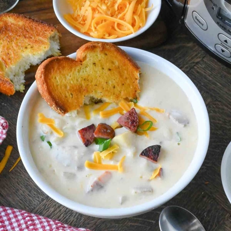 A bowl of kielbasa and potato soup served with texas toast.