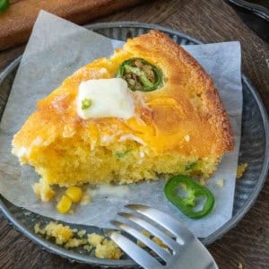 A plate with a slice of cheddar cheese jalapeno cornbread.
