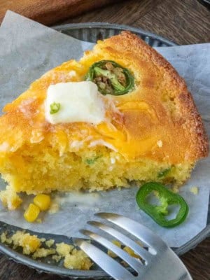 A plate with a slice of cheddar cheese jalapeno cornbread.