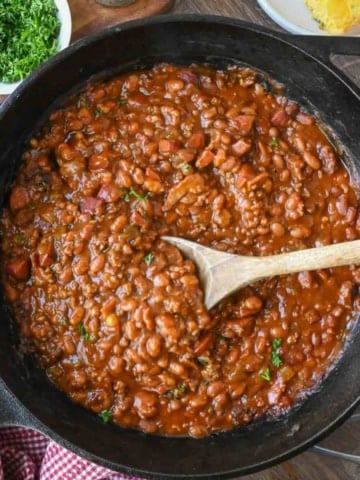 Overhead view of cowboy baked beans recipe in a cast iron skillet.