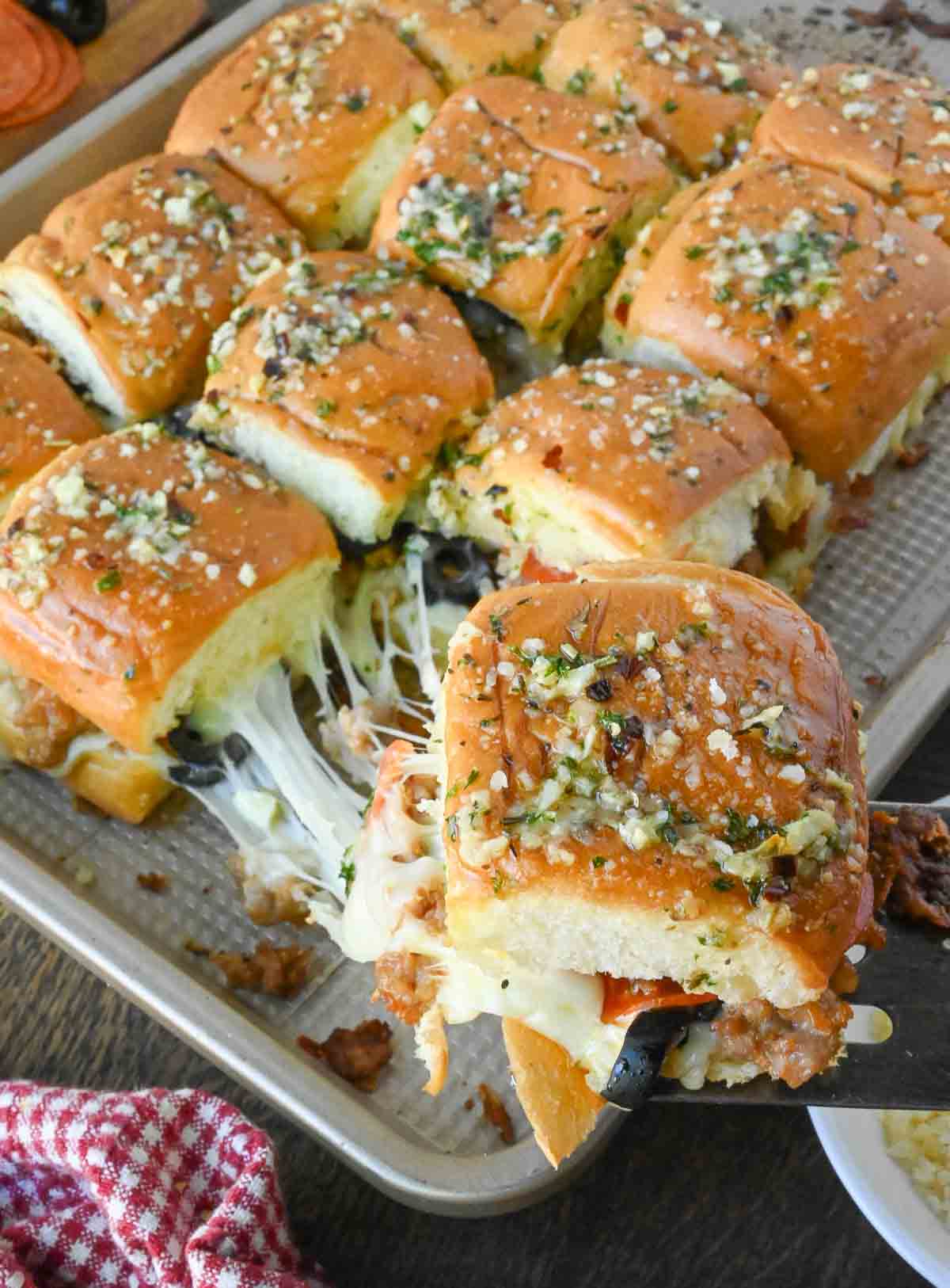 A tray with pizza sliders on hawaiian rolls.