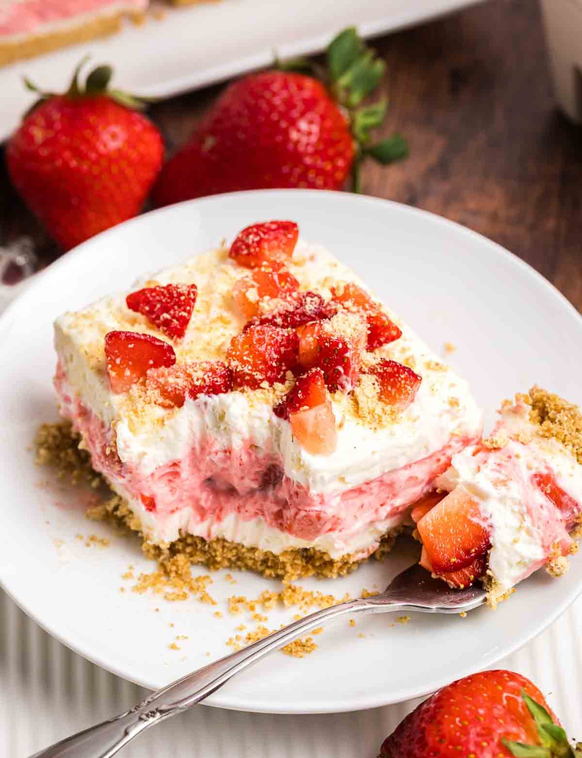 A plate with strawberry delight and a fork.