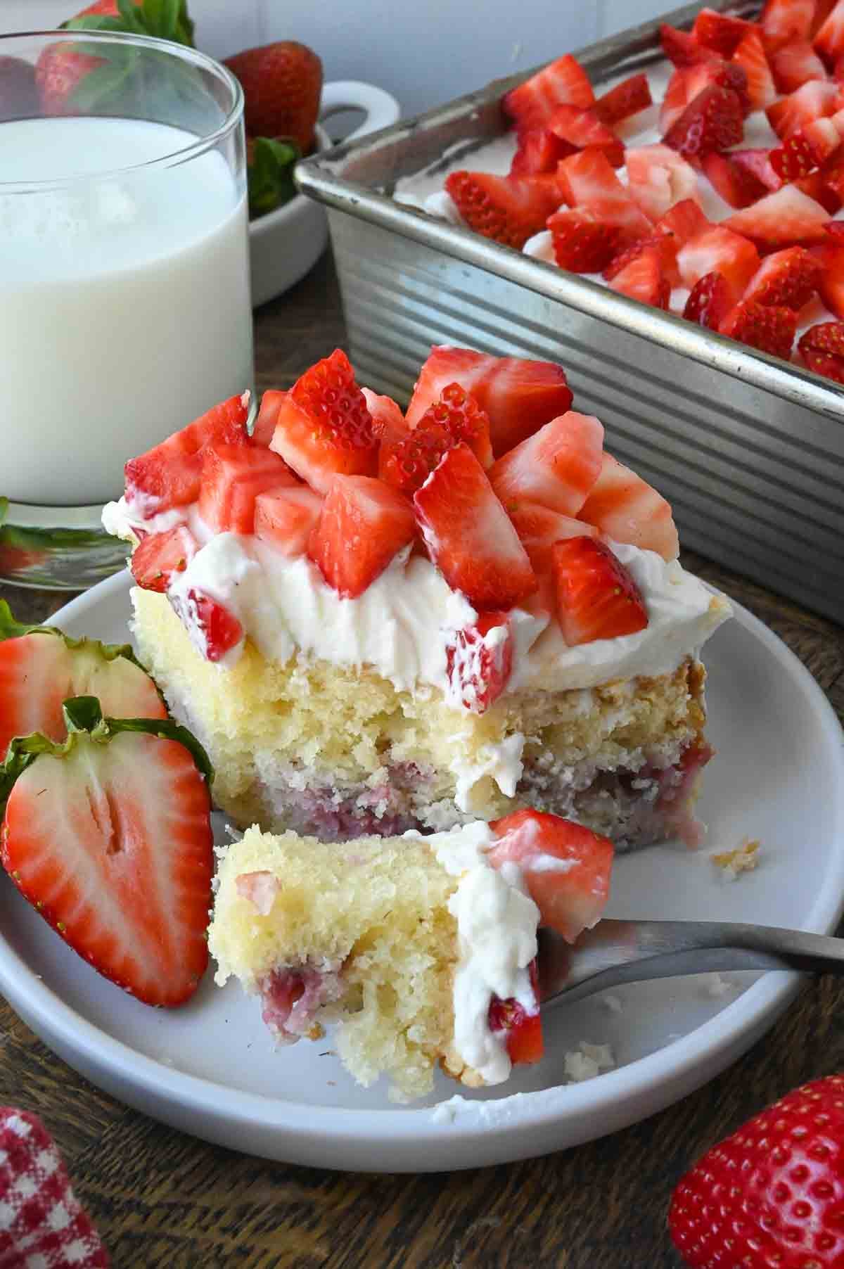 A plate of strawberry whipped cream cake.