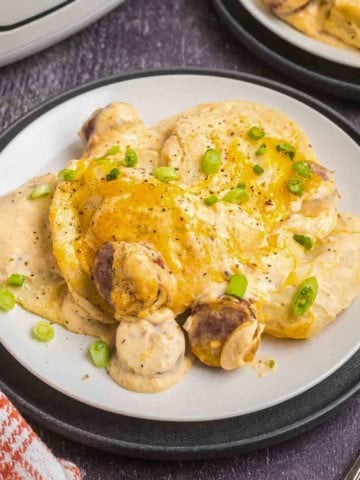A plate of crockpot pierogi casserole with green onions.
