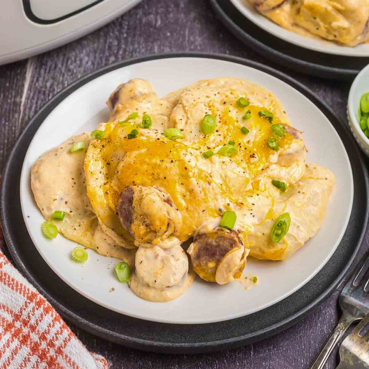 A plate of crockpot pierogi casserole with green onions.